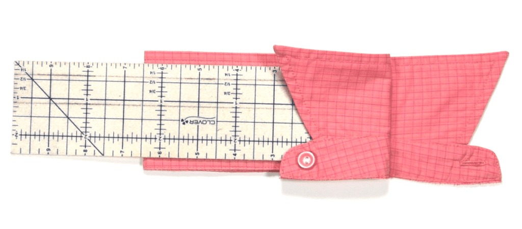 pink shirt collar folded in half with ruler and flap folded over