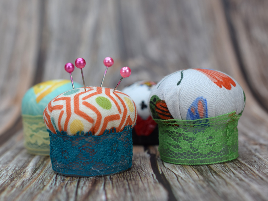 Plastic Bottle Cap Pin Cushions on Medium Wood Close